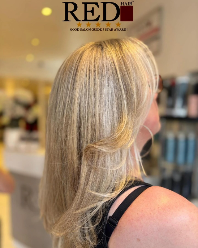 A professional stylist giving a woman a stylish haircut at Red Hair Hastings salon, showcasing a modern and tailored look.