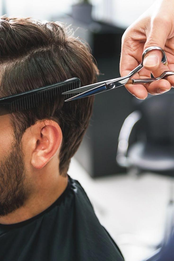 A barber at Red Hair Hastings salon providing a sharp, clean haircut for a man, emphasizing precision and style.